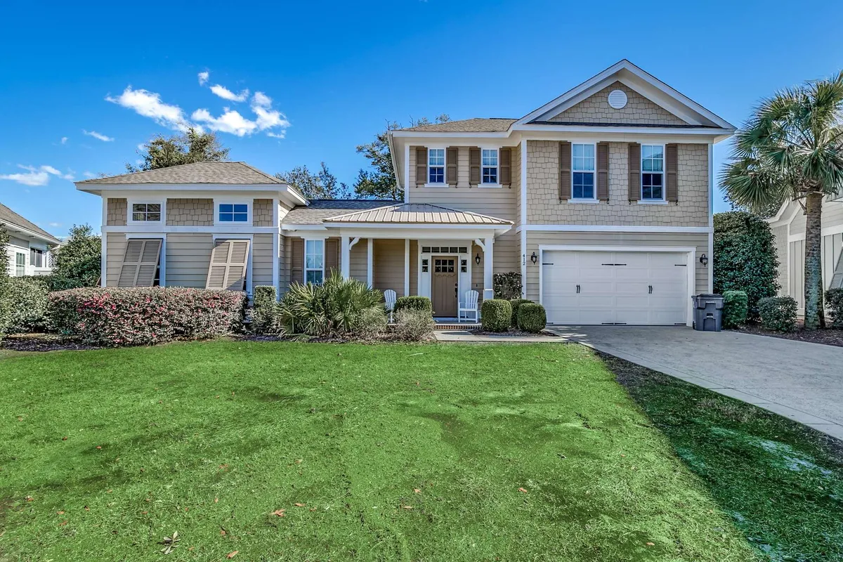 This exterior image showcases a two-story standalone house surrounded by a lush green lawn and accented by a palm tree, with a welcoming front porch. The inviting atmosphere suggests a perfect spot for relaxing outdoors and enjoying the resort's natural setting.