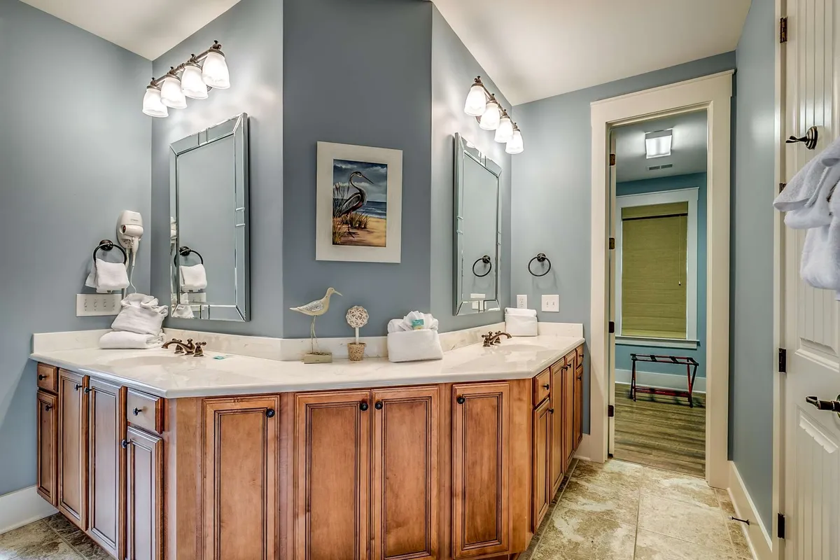 A tranquil interior space featuring dual mirrors, wooden cabinetry, soft lighting, and decorative touches creates a spa-like setting ideal for relaxation and self-care rituals.